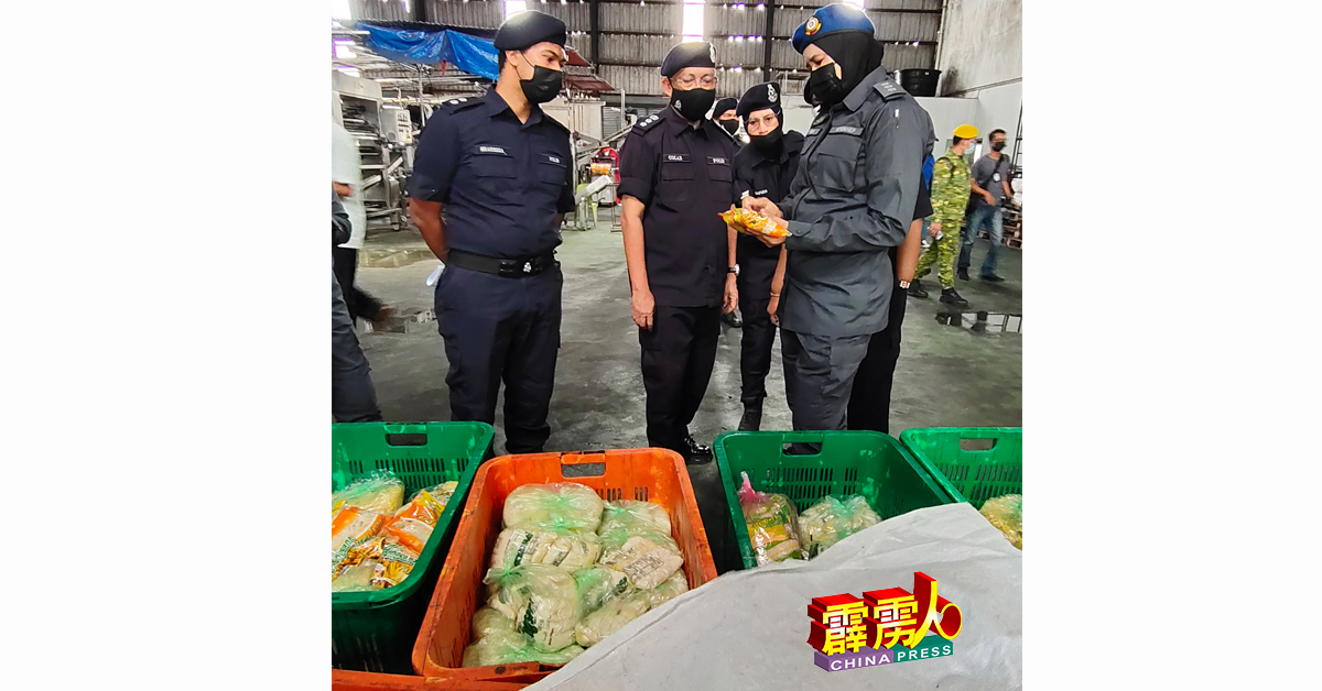 贸消部官员（右）发现麵厂的包装商标不符规格，马上通知领军的奥马峇迪（左2）。