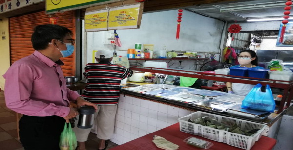 廖泰义（左）聆听小贩心声，并呼吁政府当局尽早解除餐饮业者营业时间的限制。