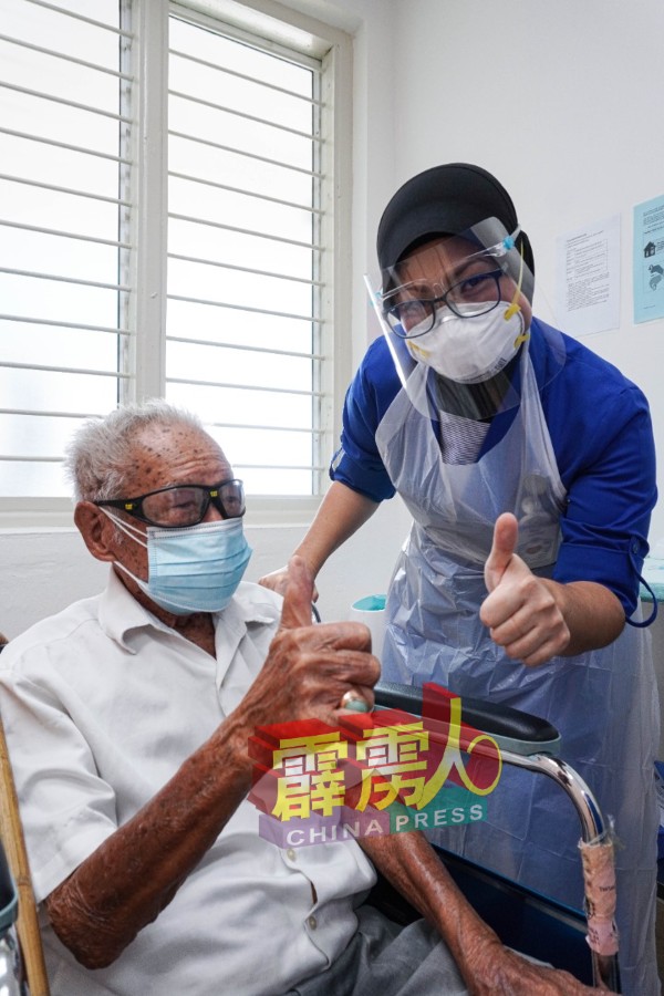 在完成接种疫苗后，张子迪（坐者）坚起姆指讚好。