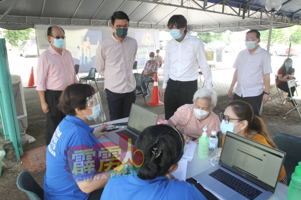陈家兴（左2）在刘敬鸿（左起）、傅宗燊及施奇沅的陪同下了解近打医葯中心接种疫苗的流程。