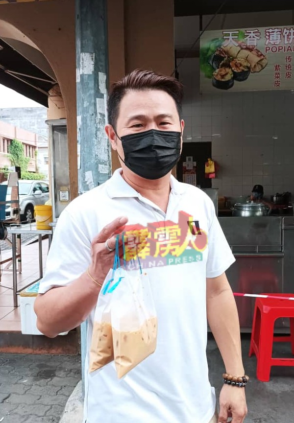 杨国俊趁着周日从文冬住家，前来旧街场打包美味的饮料和食物回家，与妻子一同品尝怡保美食。