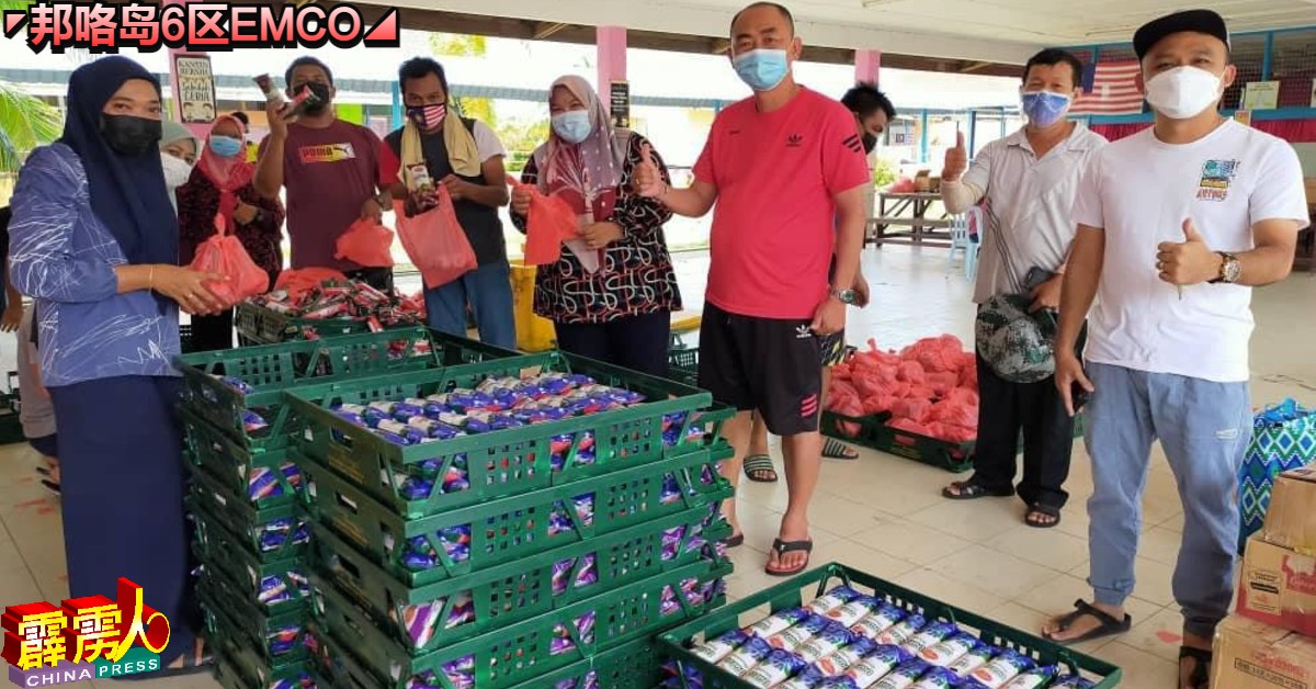 兴航渔业老板何良鸣（右3）运送4500粒面包至物资分配中心。