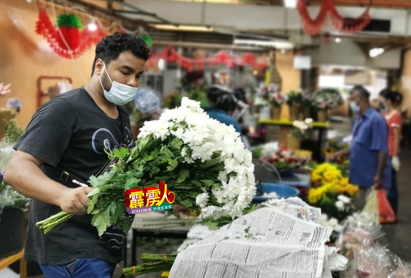 周健伦除了忙于处理门市生意，也处理网上的花卉订单。