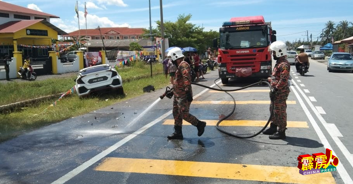 消拯员清洗车祸现场，确保没有遗下油渍及碎片，而影响其公路使用者。