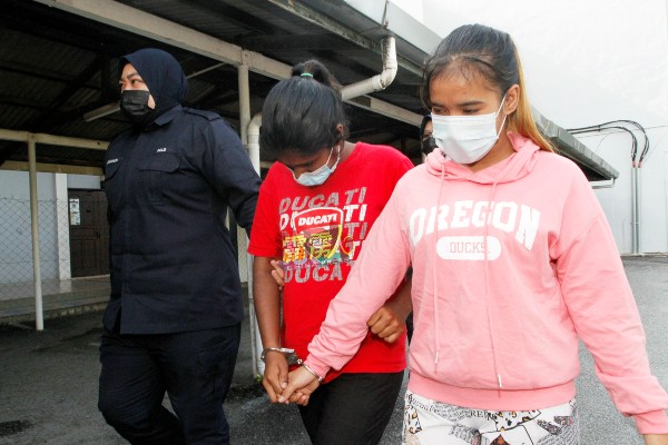 布特里阿德丽雅（右起）及玛玛兰妮由女警押往推事庭面控。