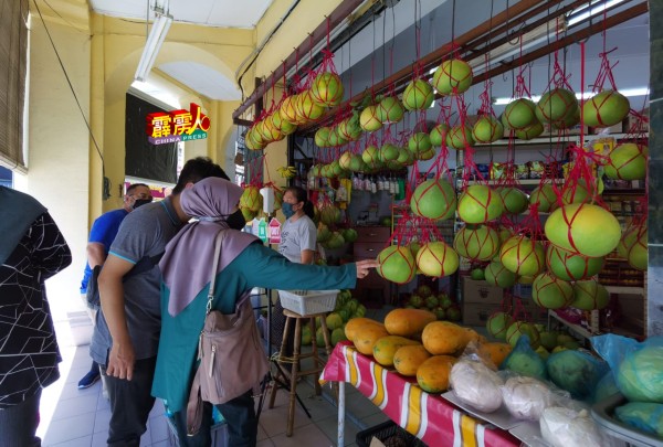 这家分別来自本地及外地的家庭成员，正在新万香园柚行选购本地土产。