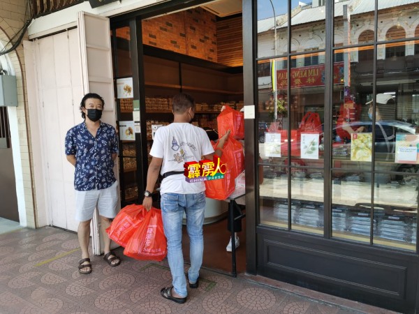 本地老字号锺汉元饼铺顾客每天络绎到来购买物品，这名顾客更是大包小包买了不少货品。