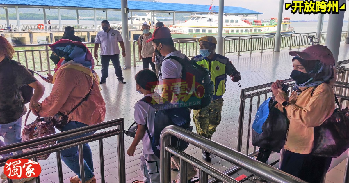 游客守秩序在红土坎码头排队乘搭渡轮前往邦咯岛。