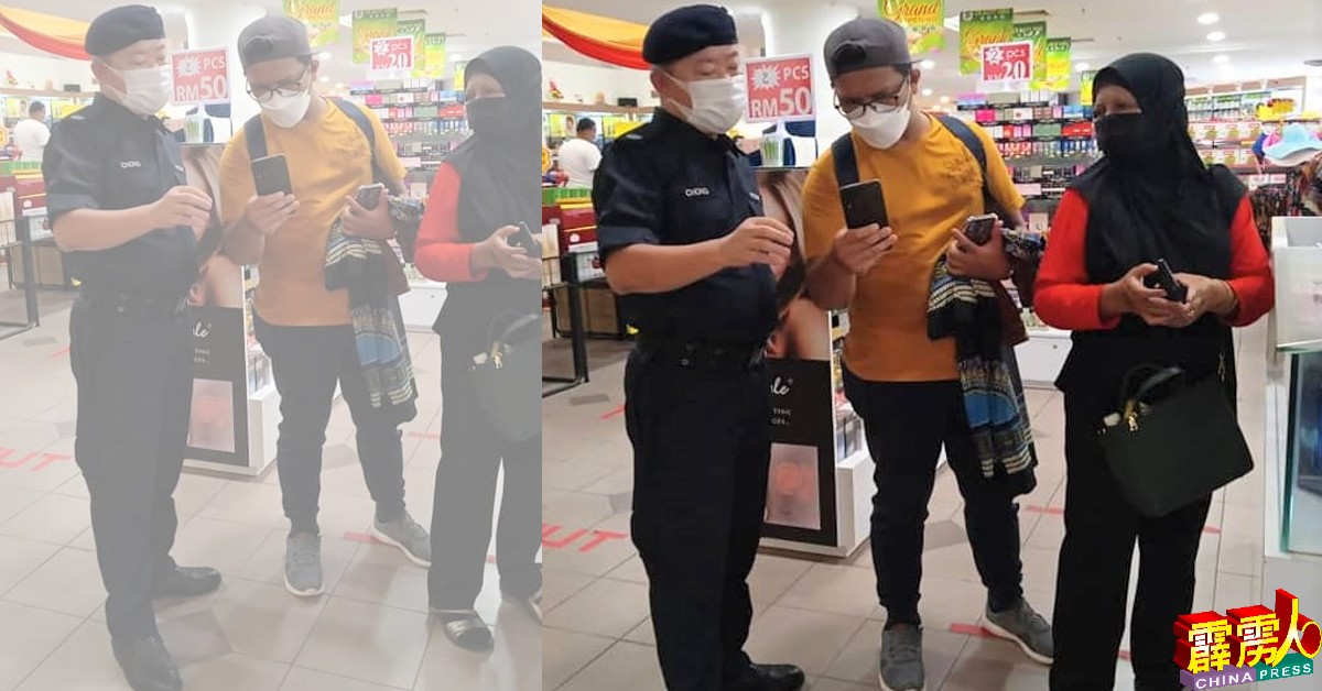锺武钦（左）在购物中心内抽样检查游客的MySejahtera记录。