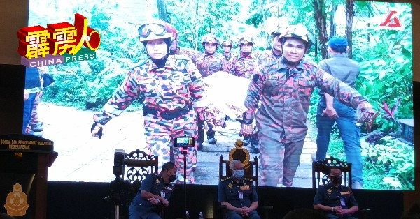 莫哈末韩丹（中）在霹雳州局长阿兹米等人陪同下，观赏消拯员义勇执行任务的短片。