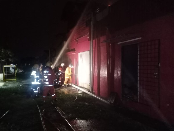 消拯员朝起火的店铺灌水，以扑灭火势。