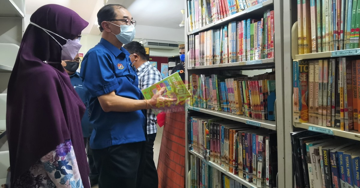 马汉顺（左2）巡视爱中图书馆，检查参考书内容。