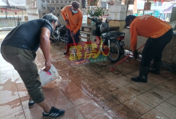 清洁工友擦洗地面顽固的污垢，汗流浃背。
