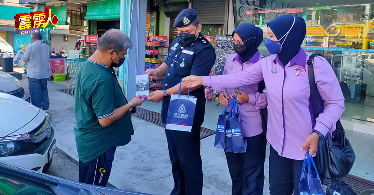和平女警与警官向民众派发礼袋及罪案防范宣传小册子。（取自江沙警区面子书）