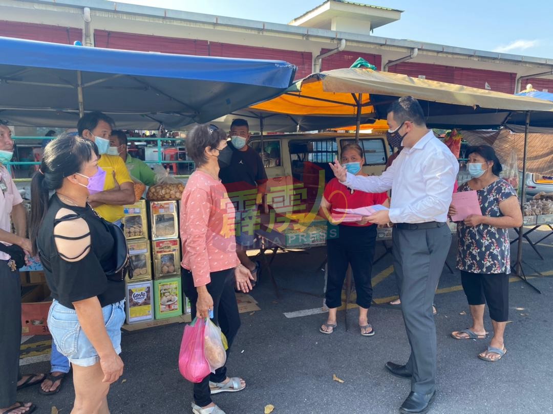 张哲敏(前排右)向小贩了解情况。