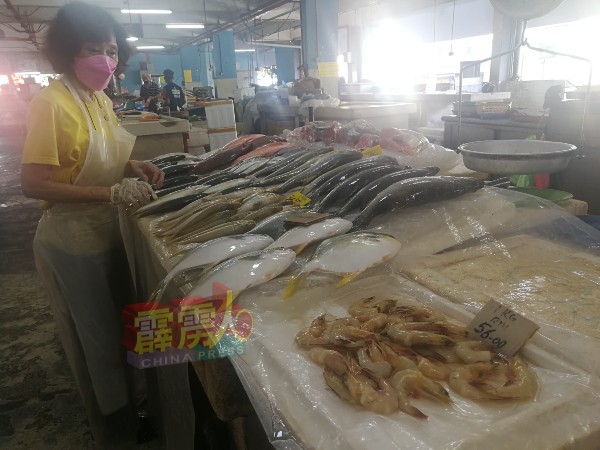 鱼贩李女士于摊位上整理鱼产。