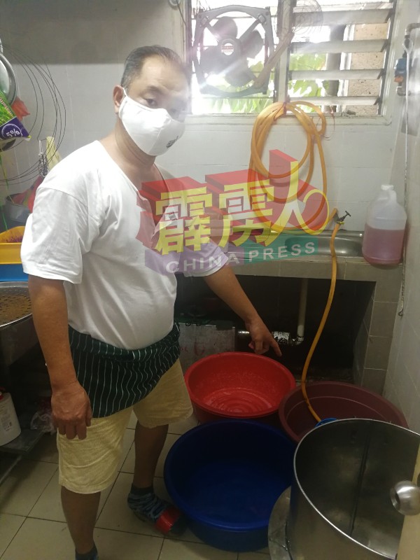 熟食区粥贩林全展示其厨房内准备了各种塑料桶盛水。