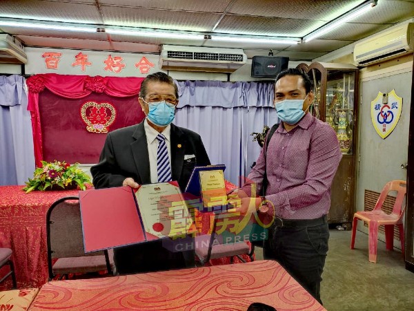 凯鲁（右）移交霹雳州卫生局，颁发给怡保精武的表扬状和纪念品给黄保生（左）。