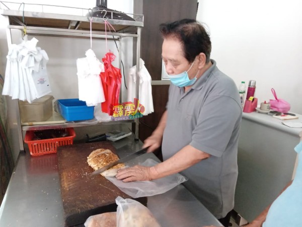 苏才（右）为顾客切麵包，并指对调整手工麵包价抱持观望态度。