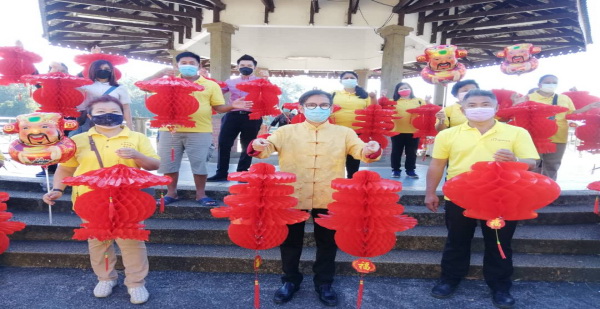 廖泰义（中）与团队们展示今年推动的“虎进甘来”活动挂上的红灯笼，左为廖皎韵，右为队长苏宗文 。
