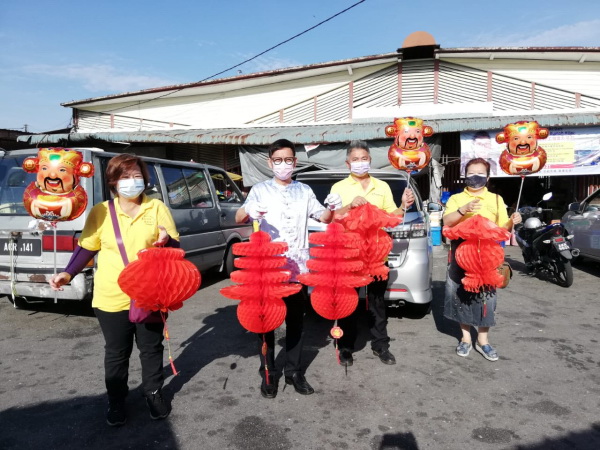 廖泰义（左2）与团队成员一起展示红灯笼，提早向太平市民拜年，左为胡小玲，右起为廖皎韵及苏宗文。