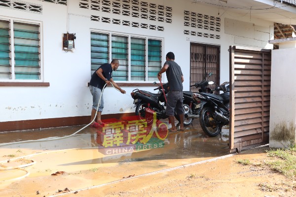 村民进行水灾善后工作，包括把屋外的黄泥浆清洗干淨。