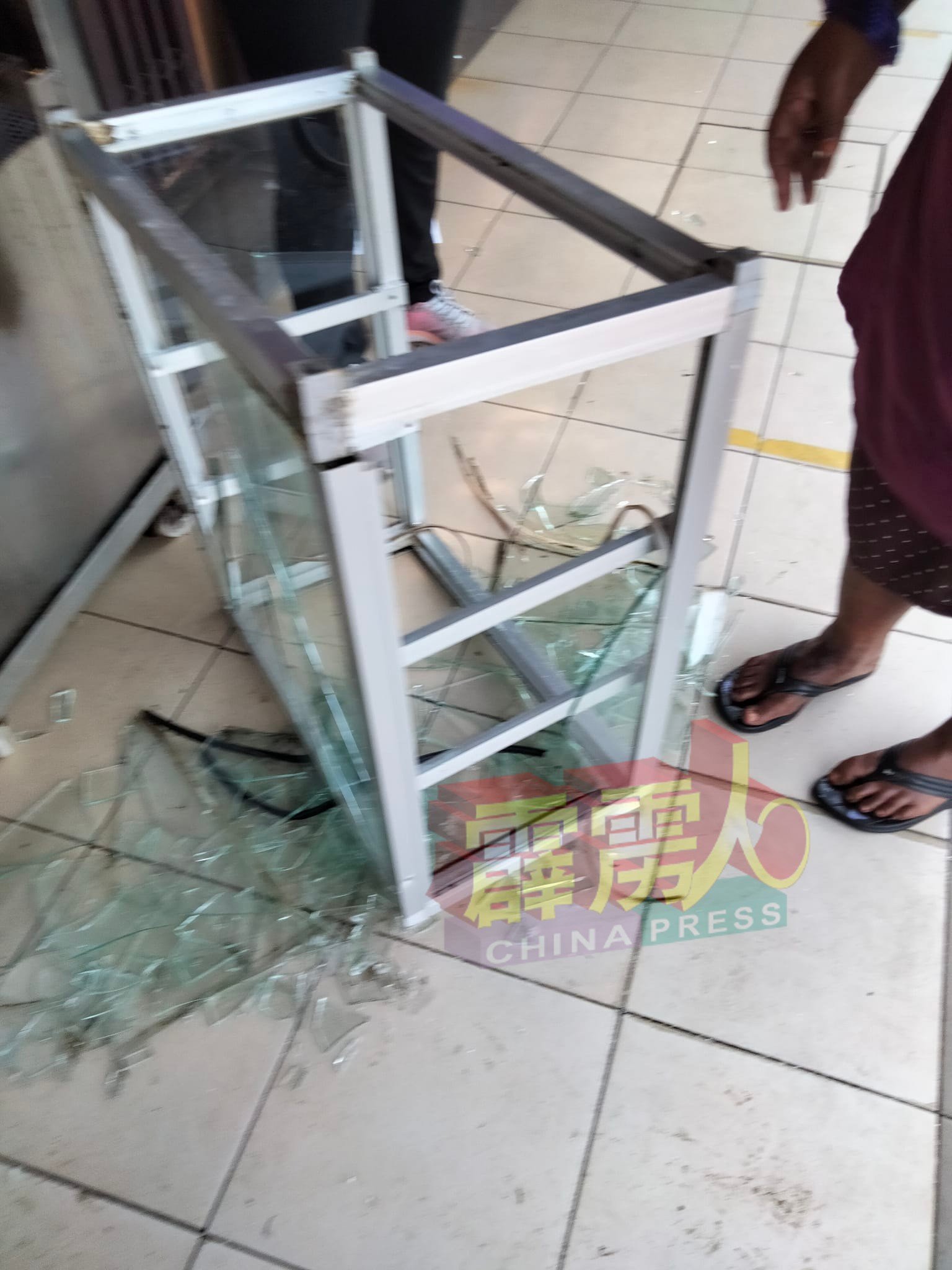 一名小贩摊位的玻璃柜台，也在混乱中被砸落地面，玻璃碎了满地。