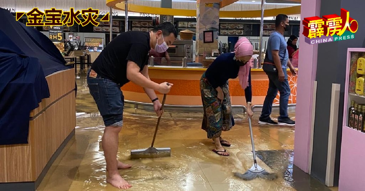 张哲敏（左）和行动党克兰芝服务团队亲力亲为协助清理污水。