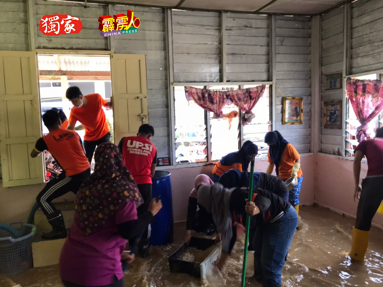 民防部队协助水患灾黎清理家园。