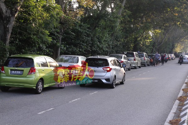 广东义山旁的道路一早就停放了许多轿车。