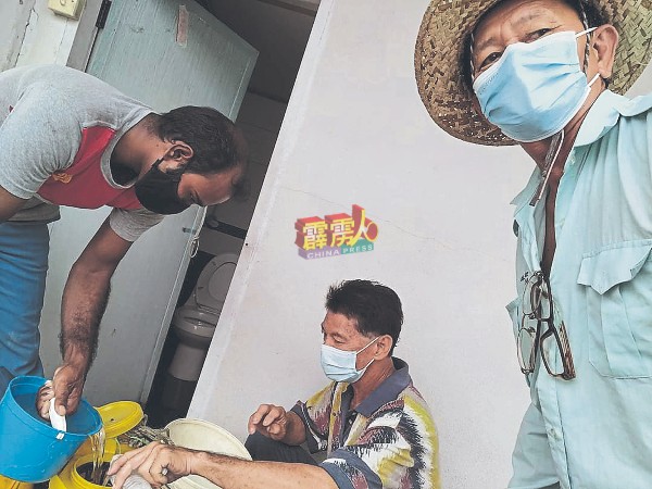 王雅霖（右）与村委，准备蚊药。