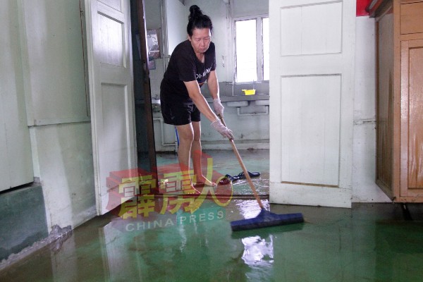 灾民郭女士周三忙着清理随着潮水冲入住家的黄泥。