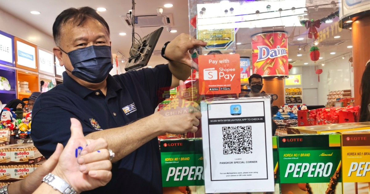 阿历山大南达林奇为邦咯岛其中一间免税店，贴上“霹雳州零售数码化倡议计划”贴纸。