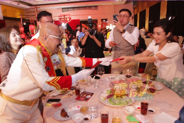 寿星王兆明于晚宴中广派红包给出席嘉宾，贺宝仪（右）开心地在接过红包之余，也祝贺王师父福寿安康。