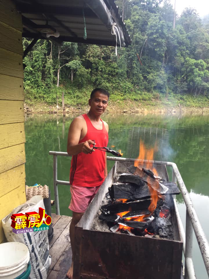 Kenny Ooi生火点炭，为游客的烧烤准备。