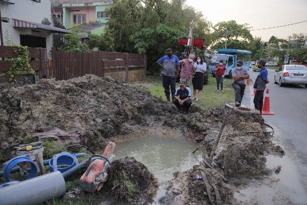 崔慈恩（站者左3）视察输水管道抢修工作，同时向居民了解制水情况。