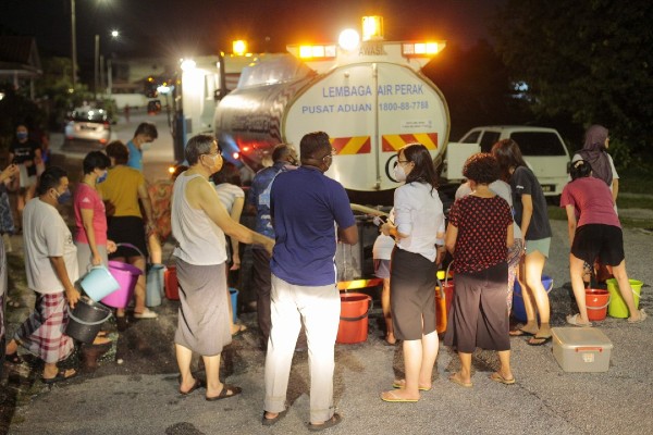 崔慈恩（前者右2）要求霹雳水务局派出水车为居民供水，水车抵达后，居民纷纷提着水桶前来取水。