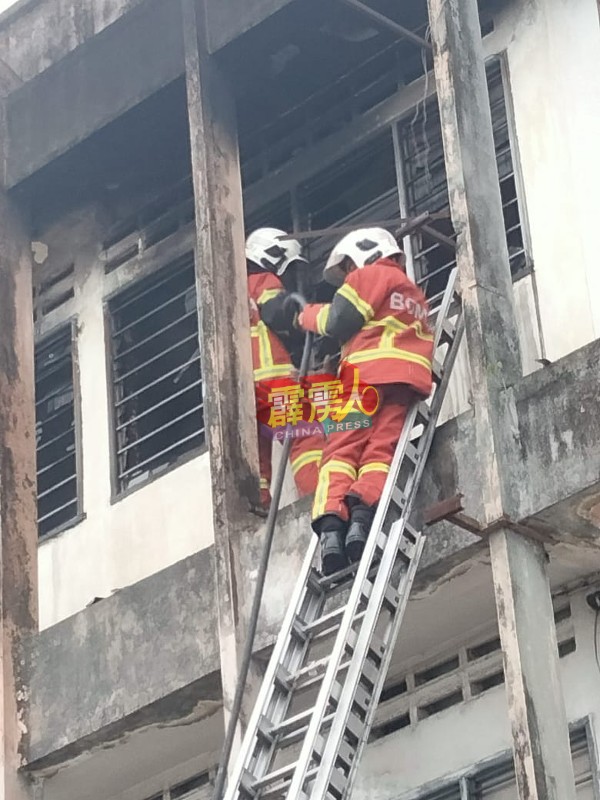 消拯员爬上梯子，从窗户外展开救火工作。