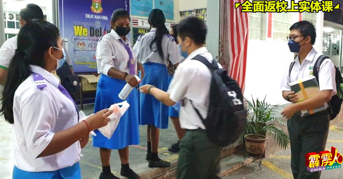 实兆远南华华中学生于进课室前消毒双手。