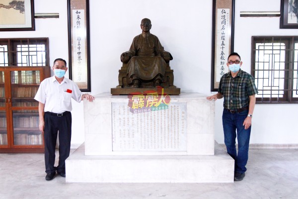 张英杰（左） 及张韵山在“仙如纪念馆”内，与先父张仙如的雕像合影。