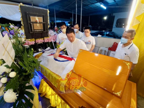 倪可敏为胡华彬的灵柩盖上火箭党旗致敬。