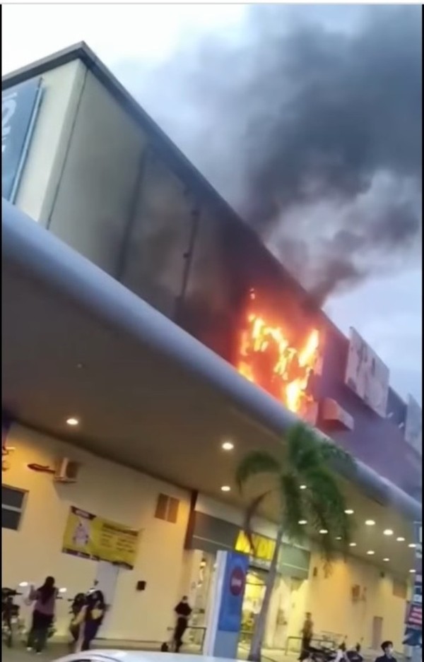 曼锐一家超市外墙上的广告牌突然起火。