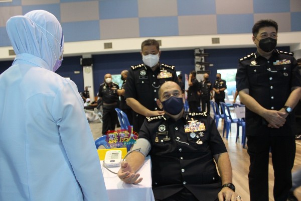 米奥（坐者）在霹雳警察日捐血活动上，测量血压。