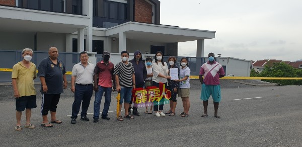 陈昭宋（右4）从居民手中接过集体签名，以寻求突发水灾解决方案。左6为怡保怡景园居协主席拿督祖朱卡里。