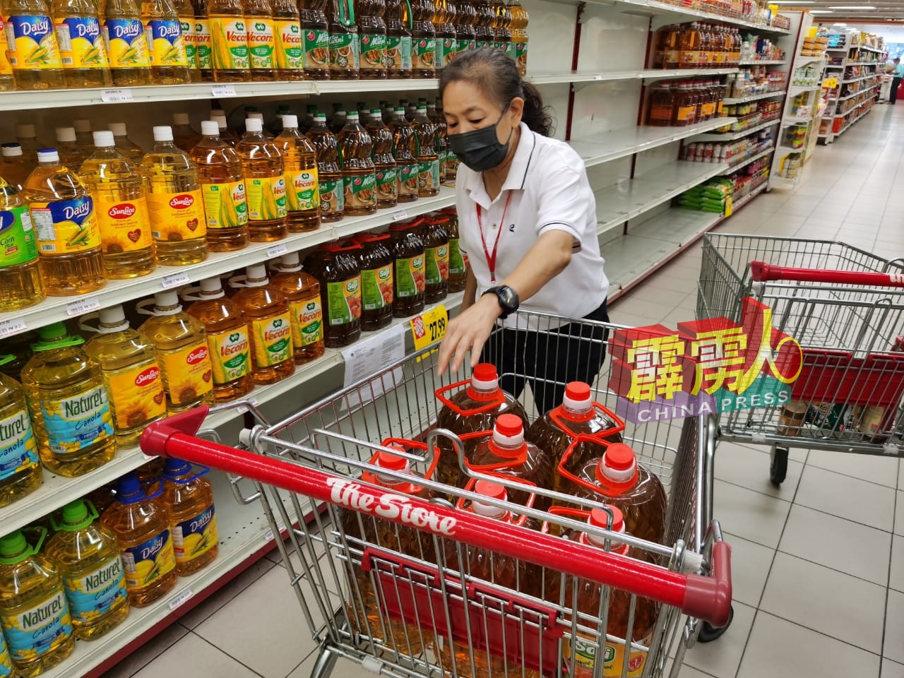 购物中心的工作人员忙于补充卖完的促销食油。
