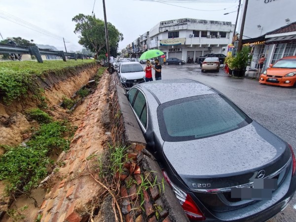 下午一场豪雨，导致围牆倒塌，压倒在停放该处的轿车。