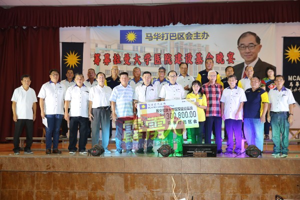 锺燊庆（前排左6）移交30万800令吉的模拟支票给马汉顺。前排右4起为黄金锭与曾秀金。