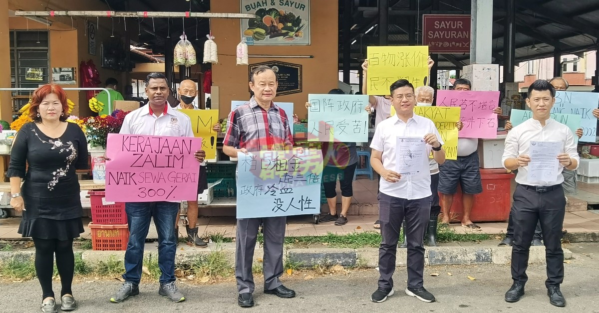 倪可汉（左3起）、张宇晨、甘文阁多名摊贩和团队，手持大字报指责曼绒市议会调租金。