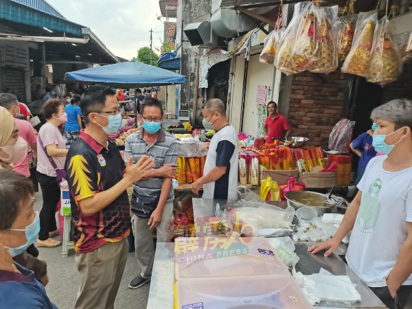 梁智伟（左）连同县议会官员前往布先巴刹，协调路边小贩及商家们营业空间的纠纷。