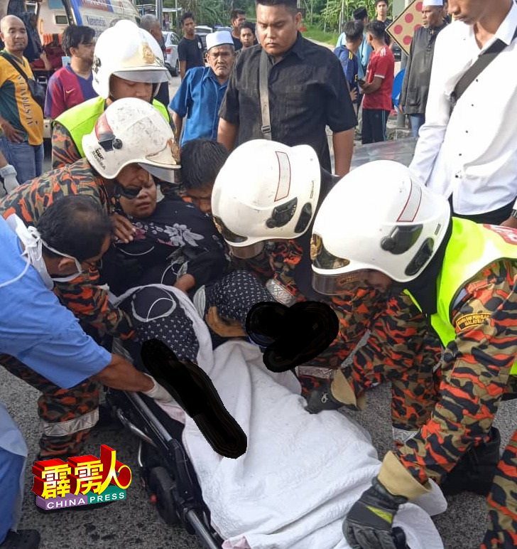 受伤女司机获救后，被消拯员抬上担架，交给救护车送往邻近医院治疗。